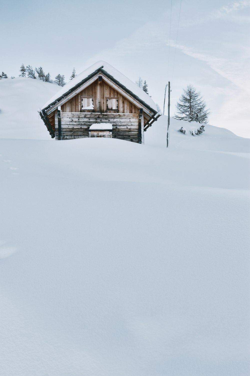 Capanna di legno marrone coperta di neve