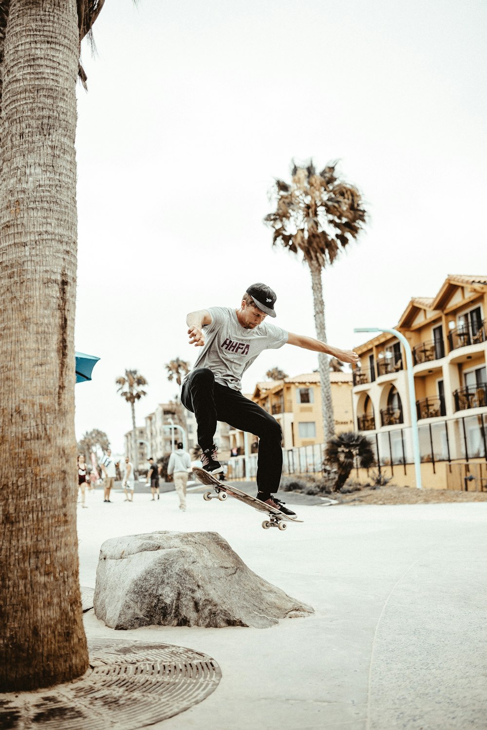 Mann spielt tagsüber Skateboard-Tricks auf dem Felsen