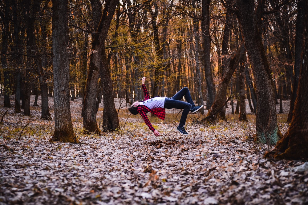 a woman is doing a handstand in the woods