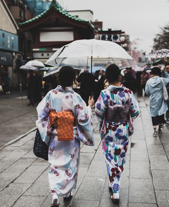 two women wearing kimono under the umbrella in Asakusa Japan
