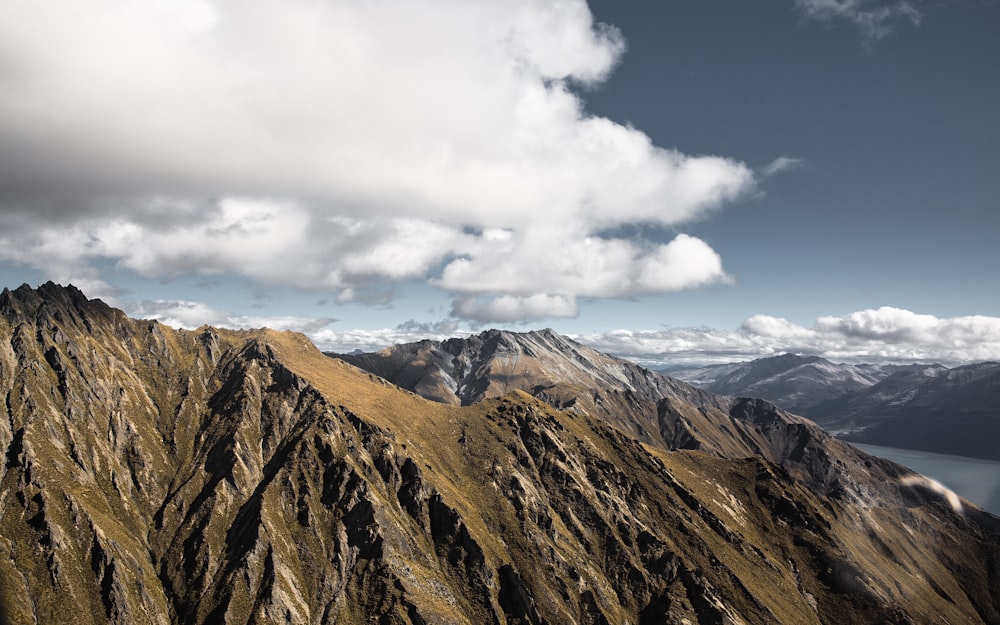 cadeias de montanhas marrons sob nuvens brancas