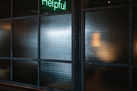 green Super helpful neon signage near window