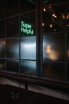 green Super helpful neon signage near window