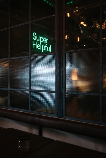 green Super helpful neon signage near window
