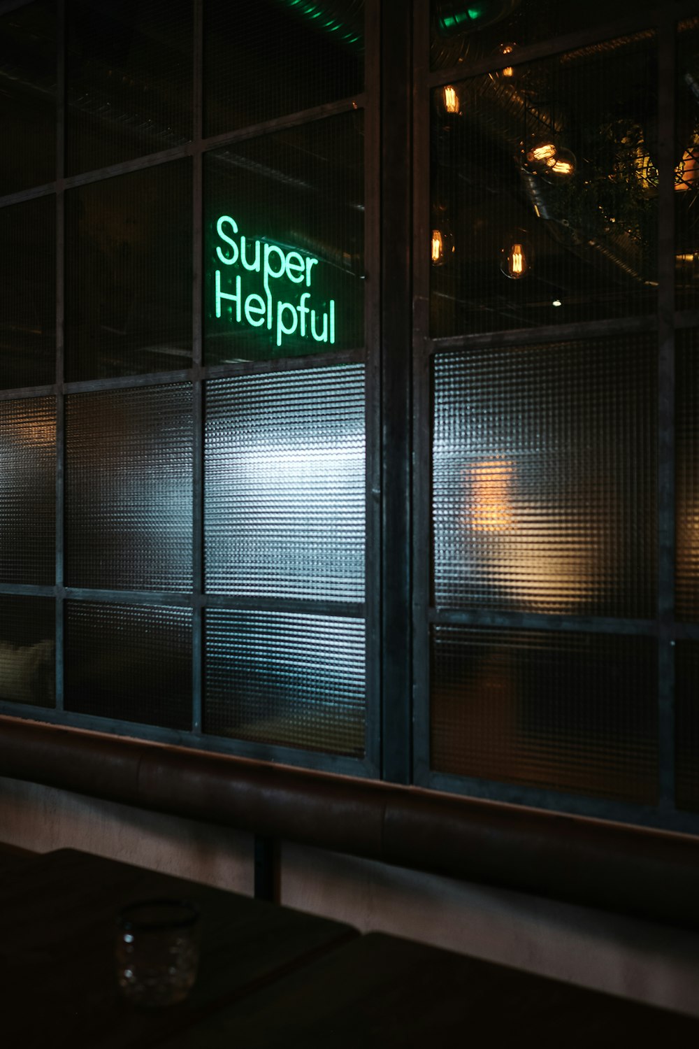 green Super helpful neon signage near window