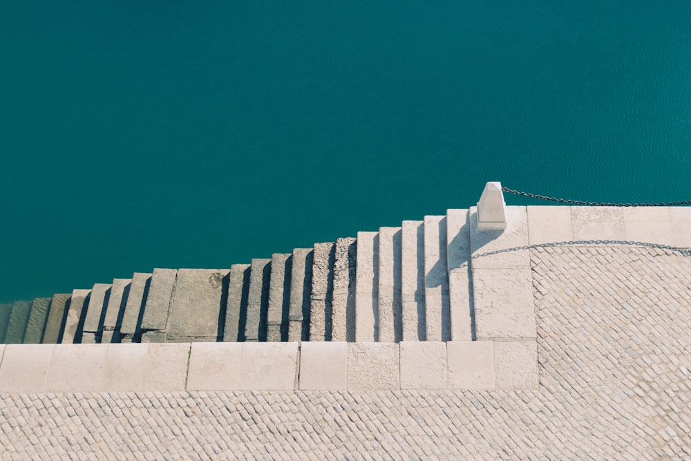 white concrete stairs near body of water