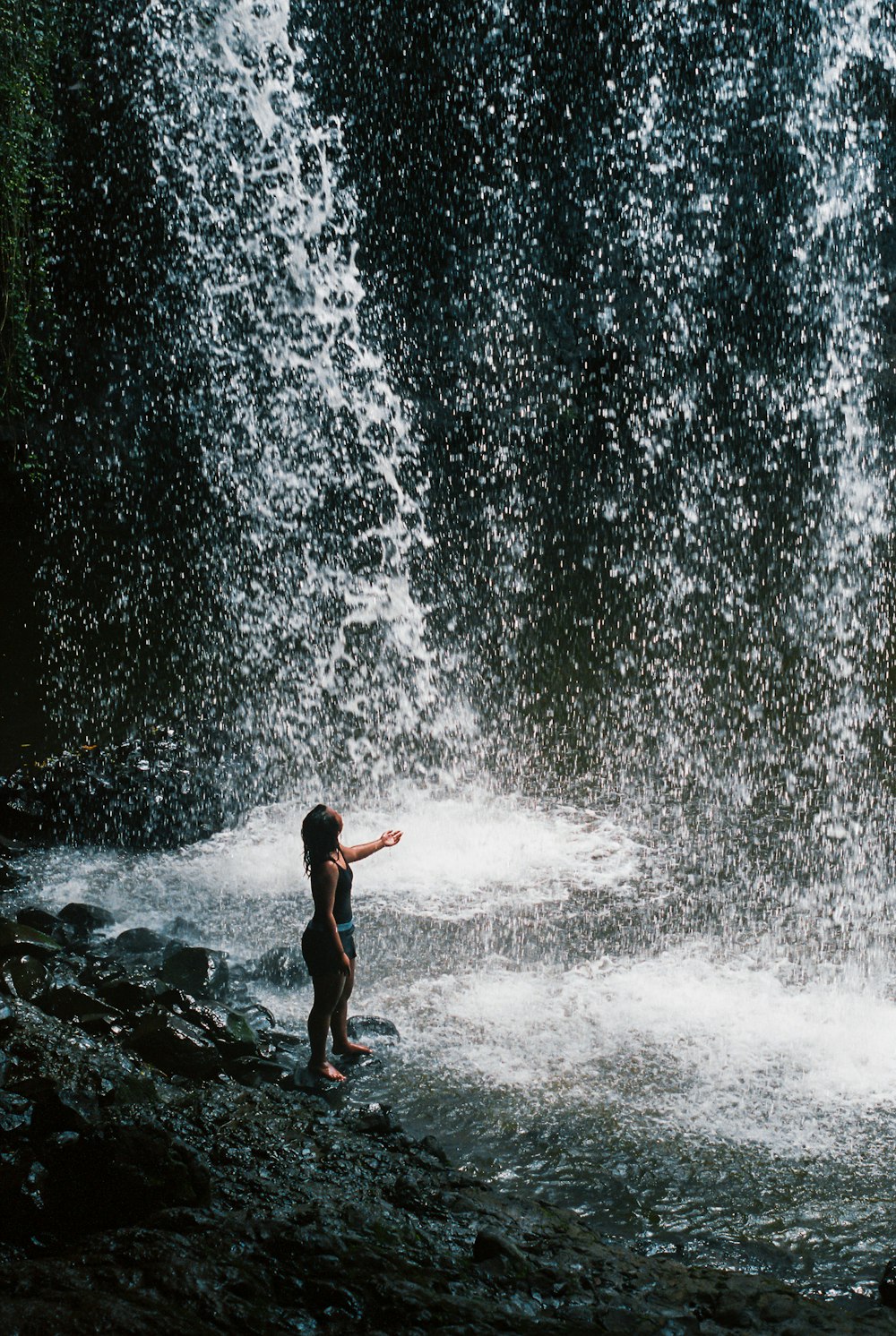 woman standing beside waterfalls