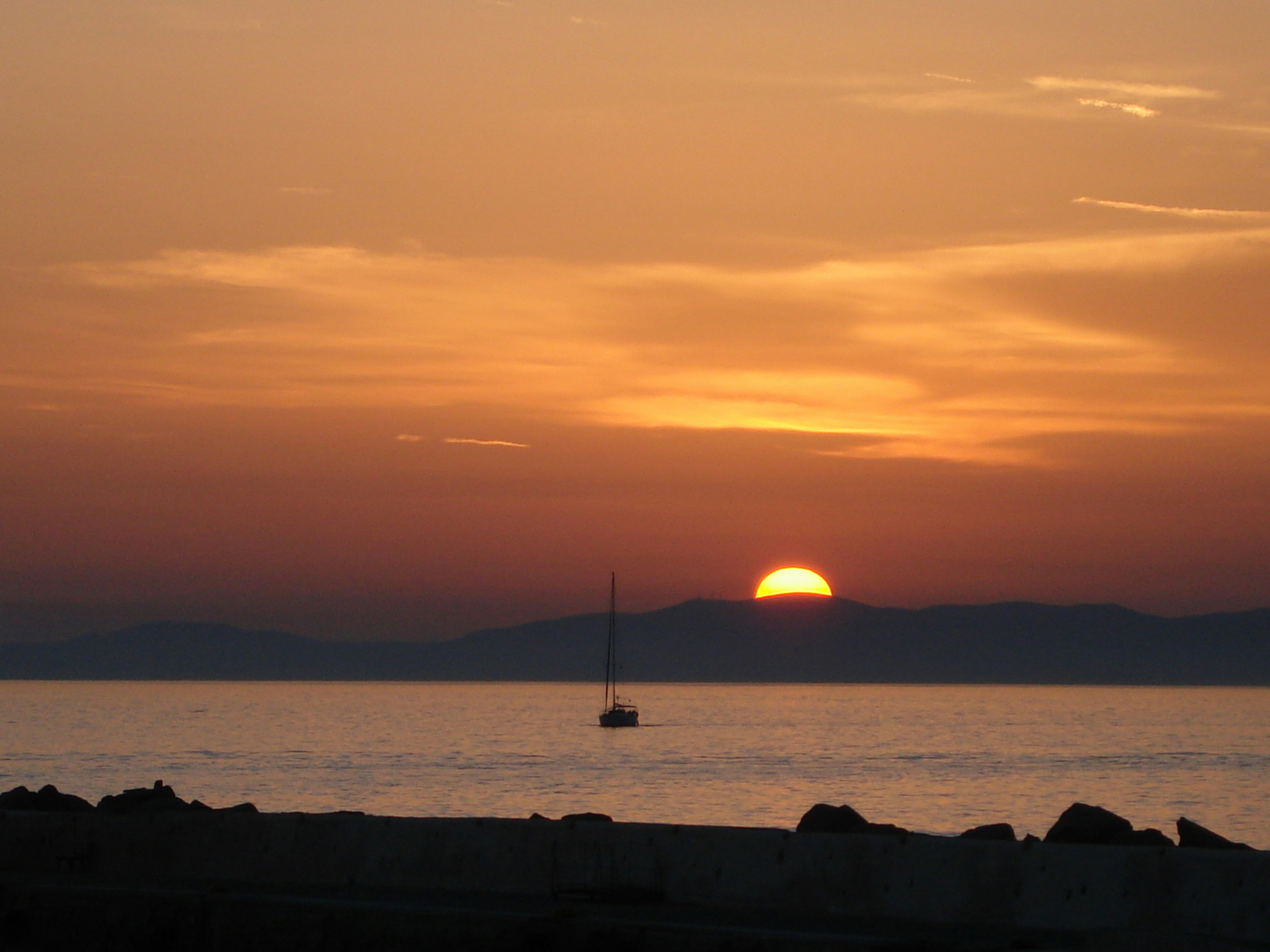 boat sailing on body of water during sunset