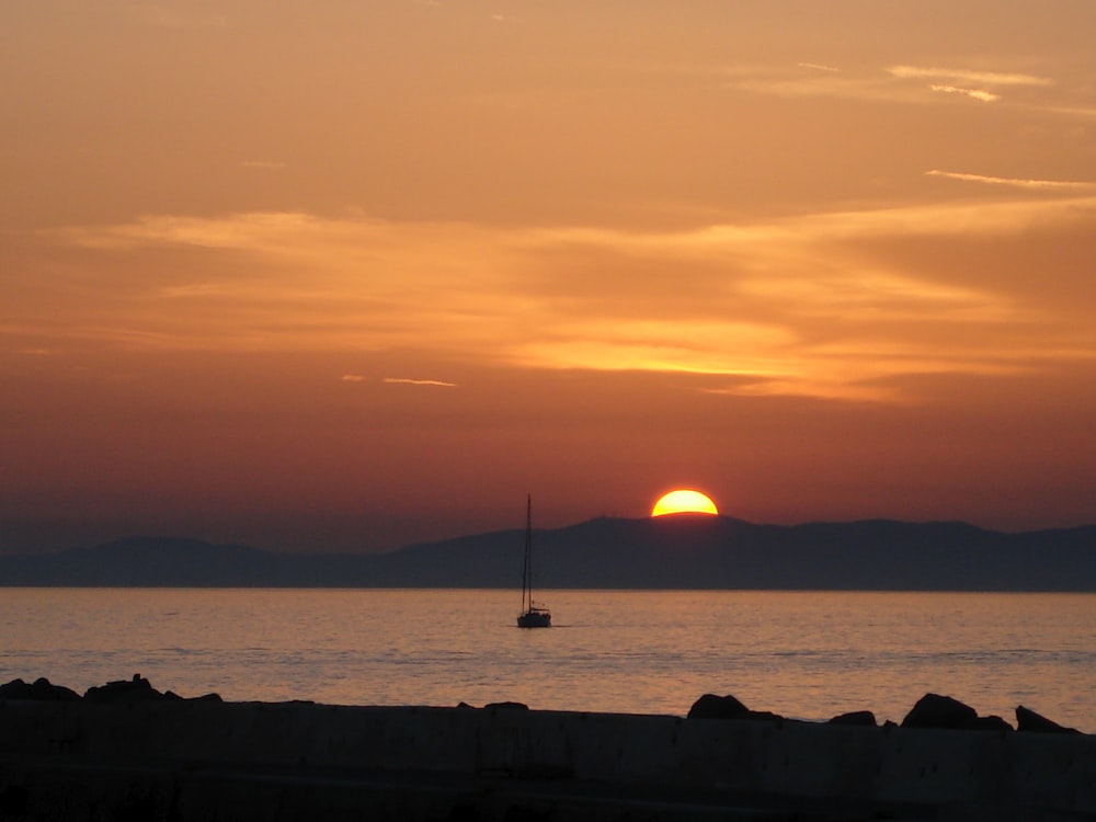 boat sailing on body of water during sunset