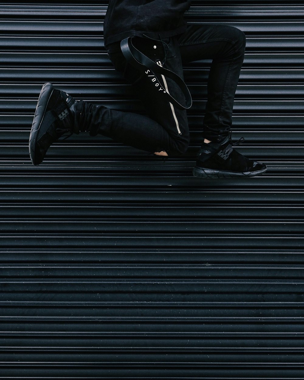 person jumping beside shutter roller