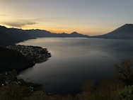 body of water between mountain at golden hour
