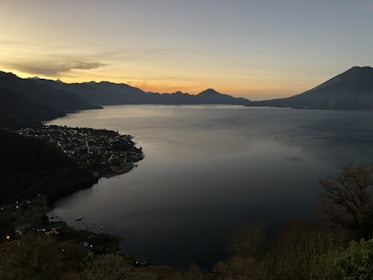 body of water between mountain at golden hour