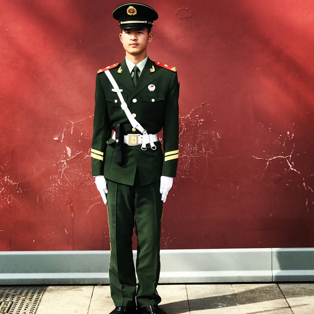 man standing near red wall