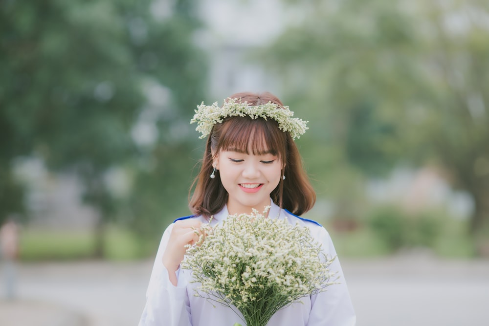 woman holding white petaled flowers