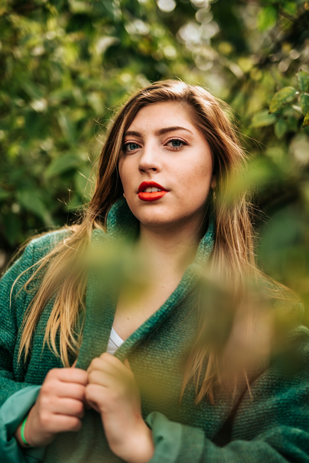 woman standing beside green leafed trees