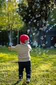A joyful child running with colorful balloons in the play yard.