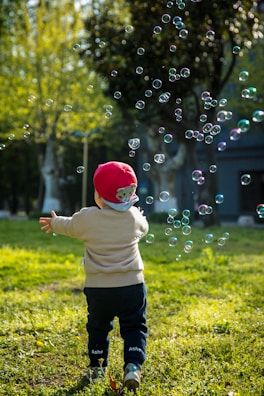 A joyful child running with colorful balloons in the play yard.