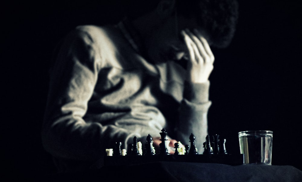 チェス盤を持ってテーブルに座っている男