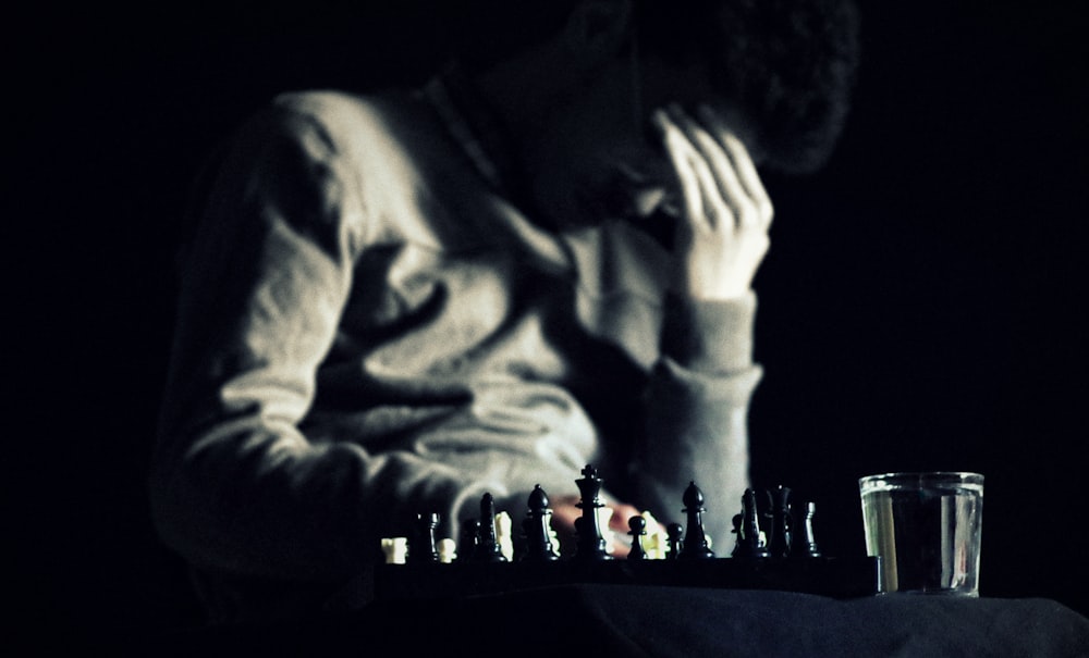 a man sitting at a table with a chess board