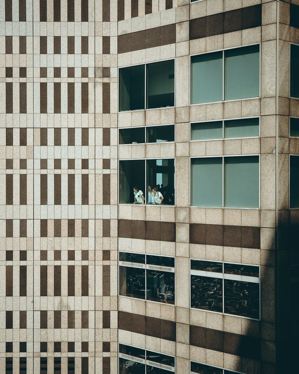 three persons at building window