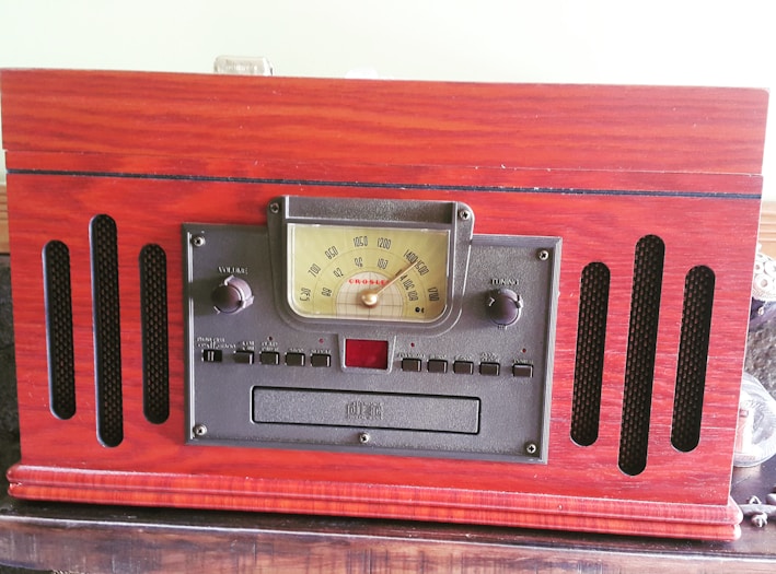 A sleek vintage-style radio with wooden casing and glowing dials, sitting on a cozy tabletop.