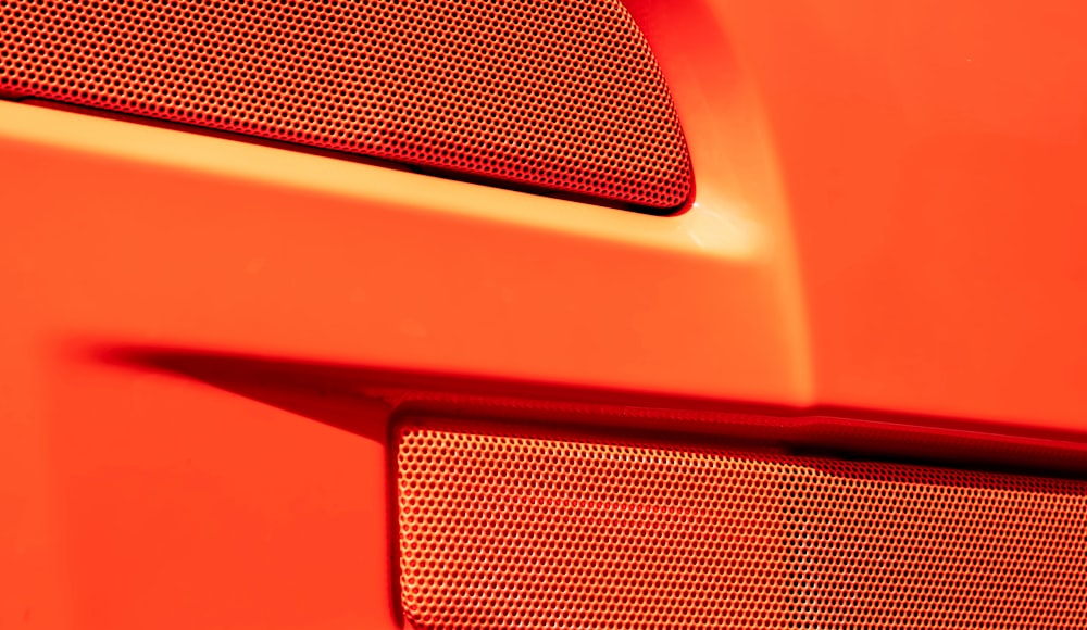 a close up of a red car's grille
