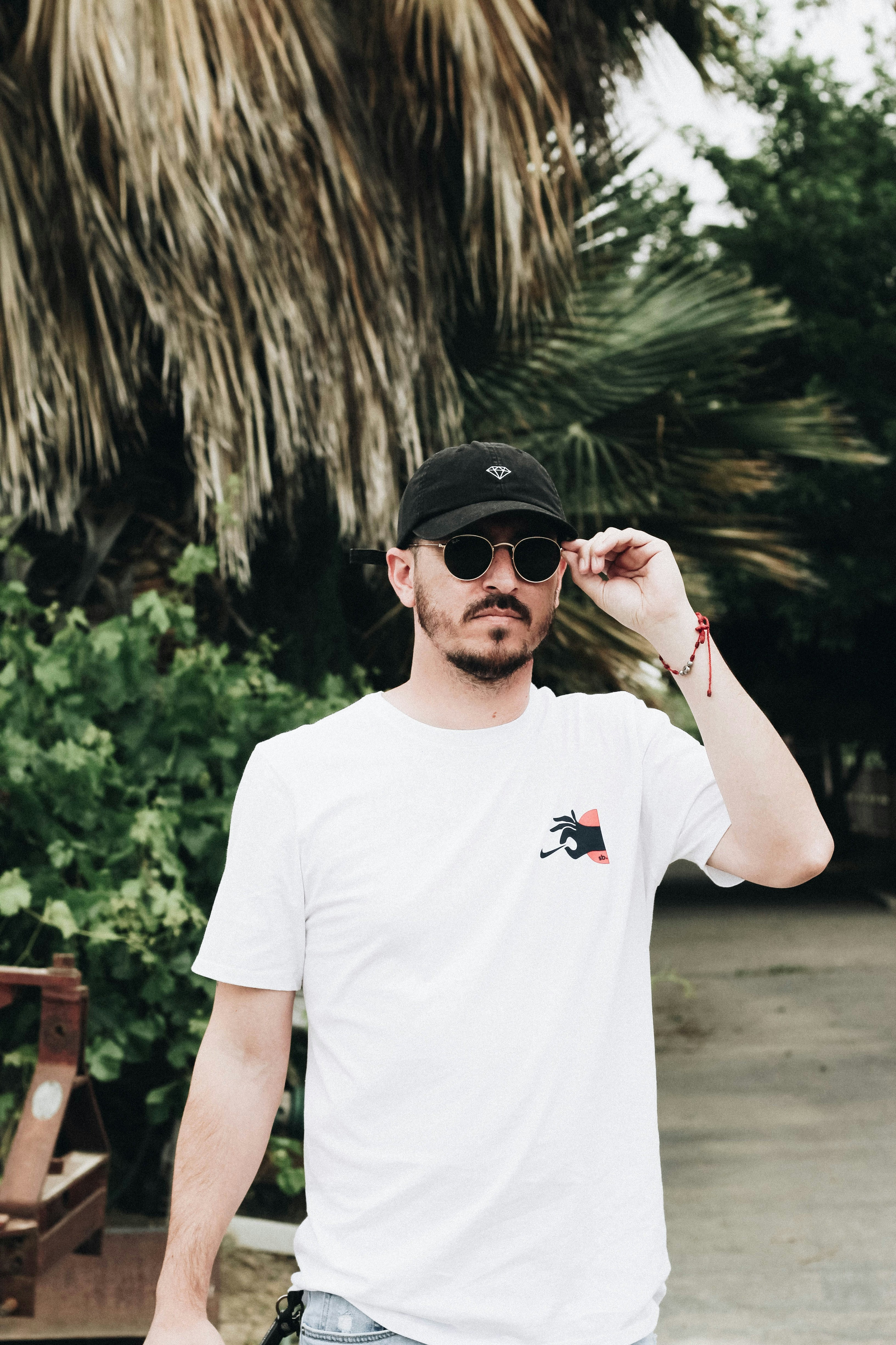 great photo recipe,how to photograph among the palms; man standing outdoor holding sunglasses