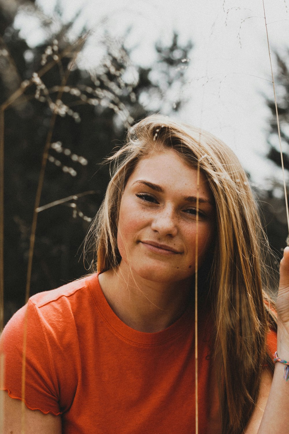 close-up photo of woman in orange crew-neck shirt