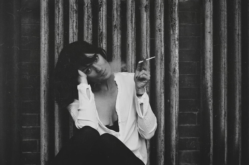 grayscale photo of a woman holding a cigarette