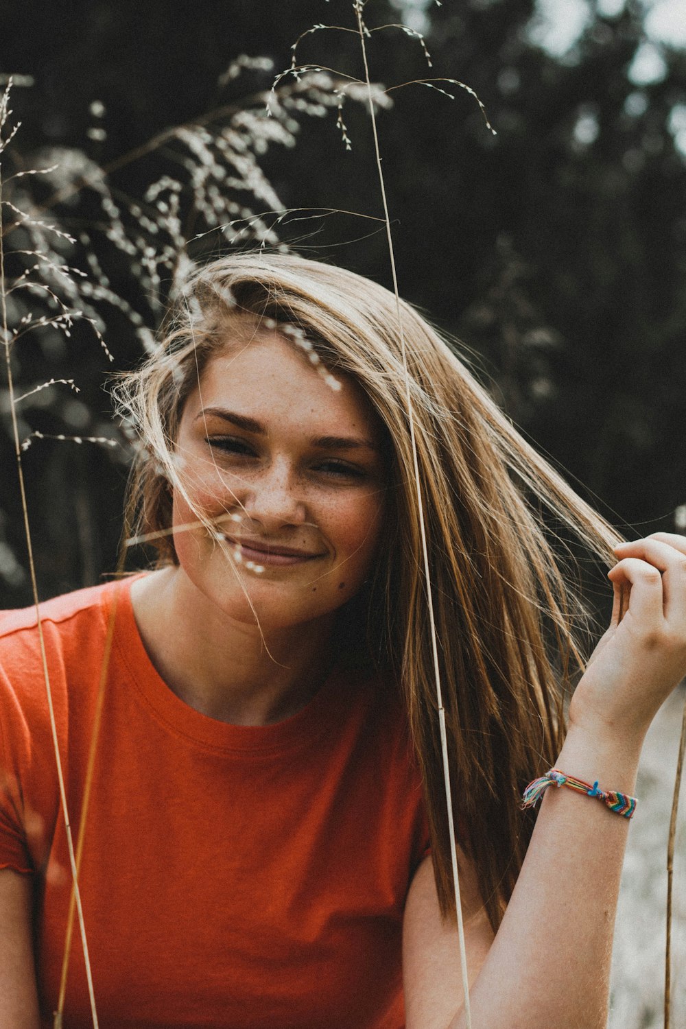 close-up photo of woman in orange crew-neck shirt