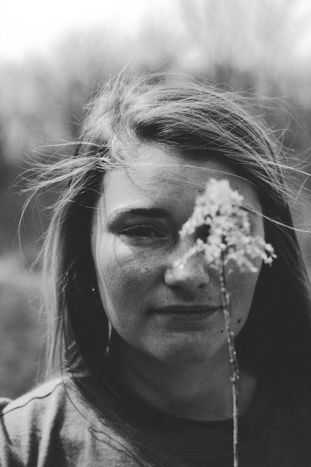 Photographie sélective de mise au point d’une femme tenant une fleur