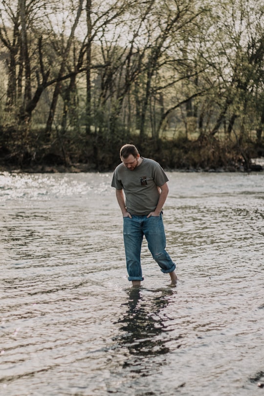 man walking in the lake at daytime in Arkansas United States