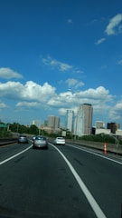 A map with a car moving from one city to another under clear skies.