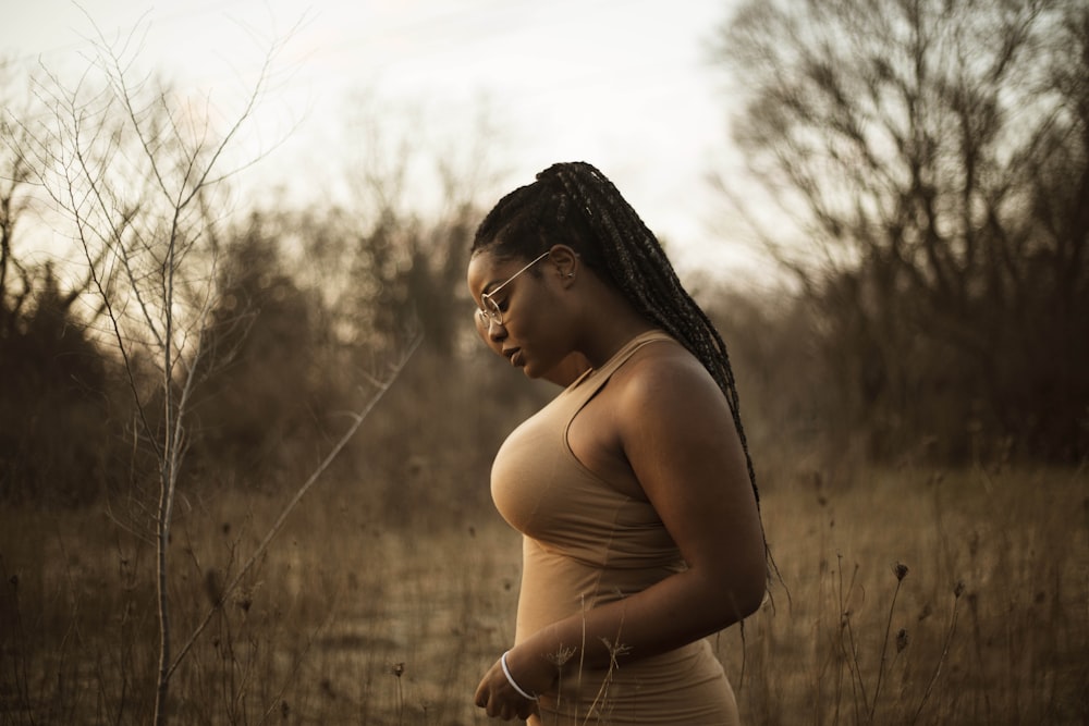 woman wearing brown tank top standing near grass