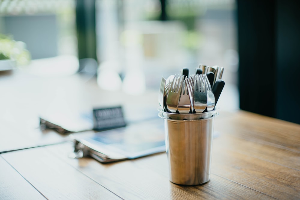 selective focus photography of cutlery on bucket