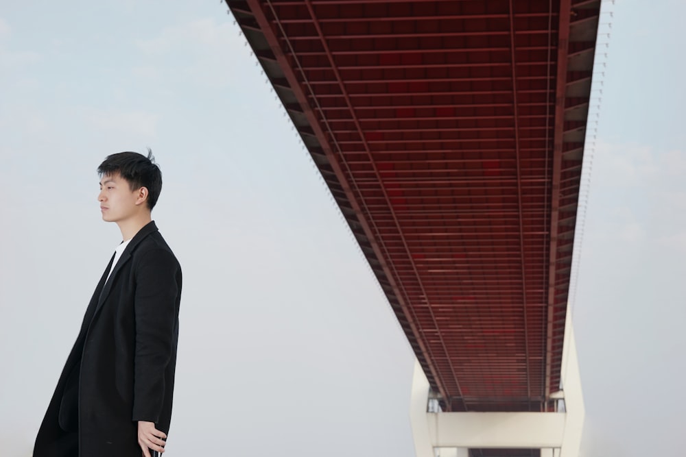 man standing under brown bridge