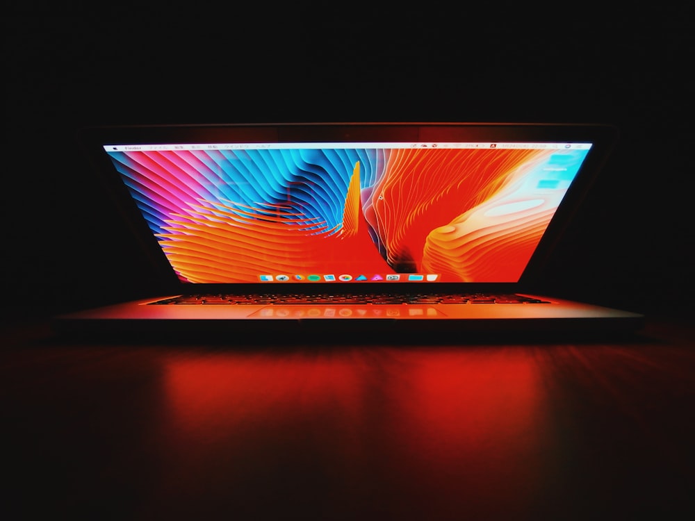 silver MacBook on brown wooden surface