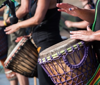 people playing goblet drums during daytime