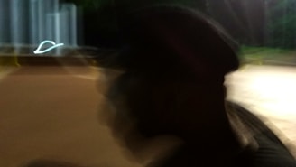 A silhouette of a figure in motion, dressed in layered clothing, captured with gentle shadows and calm tones.