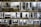 A collection of black and white photographs is displayed on a stone wall, each pinned by clothespins. The images showcase various cityscapes, urban scenes, and people, including trams, bridges, and figures with umbrellas. The overall presentation emphasizes contrast and composition.