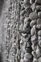 Close-up of a sturdy retaining wall built with natural stone, blending into a landscaped garden.