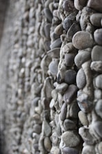 Close-up of a sturdy, modern retaining wall made from natural stone in a suburban backyard