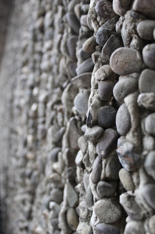 Wide view of a beautifully constructed retaining wall made of sturdy, natural stone blocks.