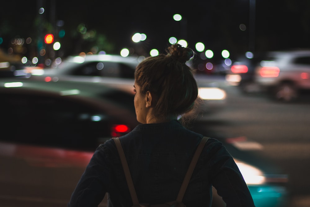 man standing wearing backpack near car paks