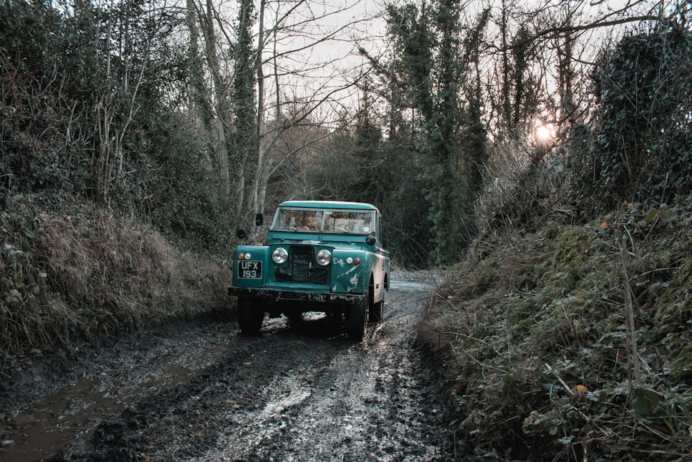 green car on rough road during daytime