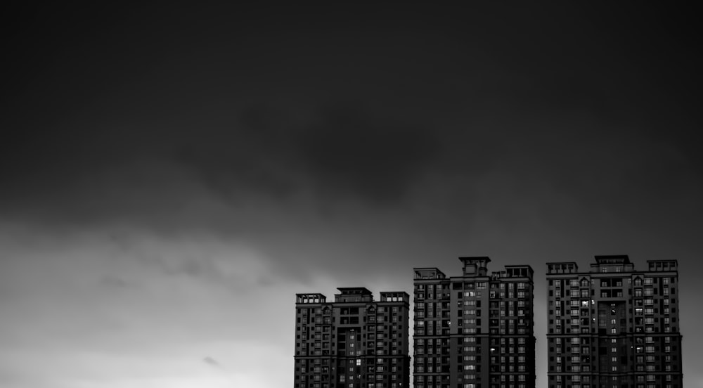 grayscale buildings under cloudy sky