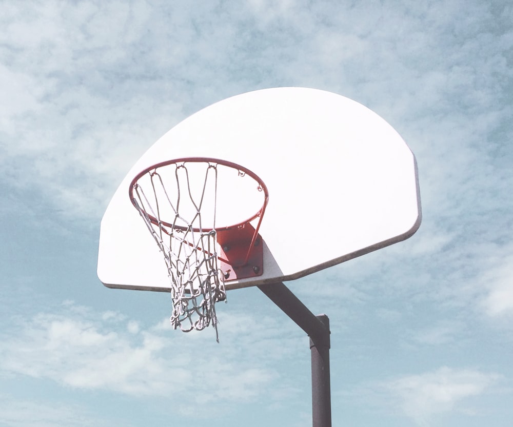 low-angle photography of basketball ring under cloudy sky