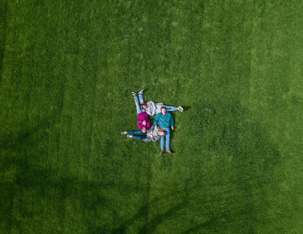 four people on green field at daytime