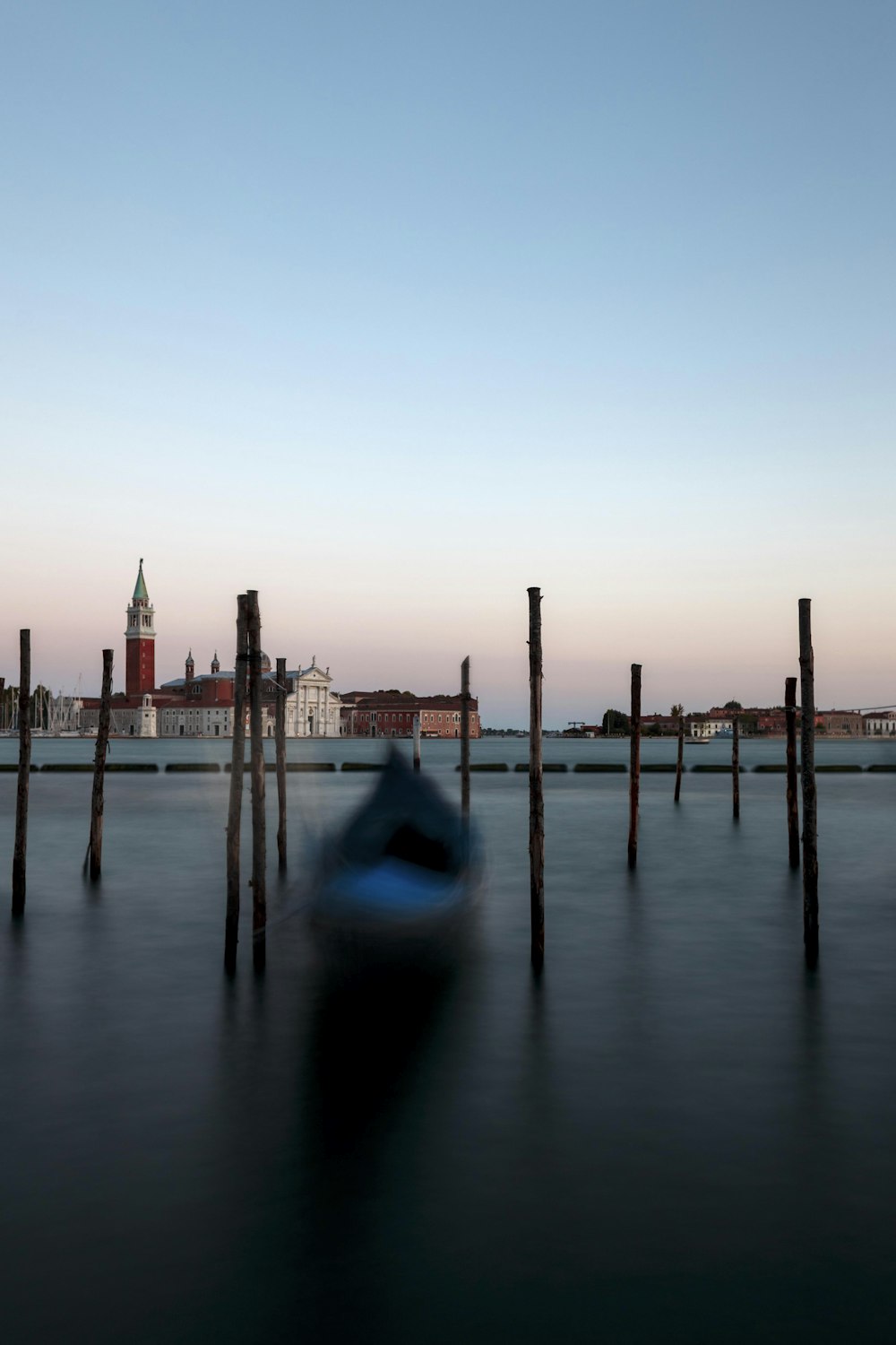 gondola on body of water near brown posts