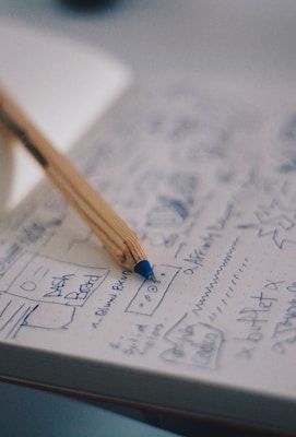 blue ballpoint pen on white notebook